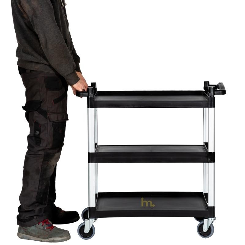 Vista de profil del Carro con 3 bandejas de polipropileno (H 850 x L 820 x l 400 mm) y con un hombre que tiene el carrito.